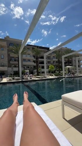 Person enjoys poolside relaxation at Tivat resort facility