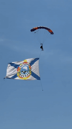 Skydiver descends with flag over Ussurijsk, Russia