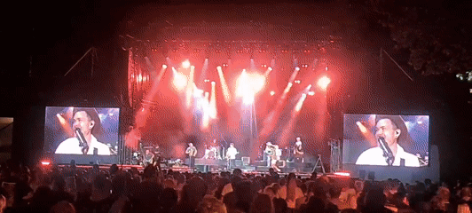 Outdoor concert night in Klagenfurt, crowd packed, stage blazing