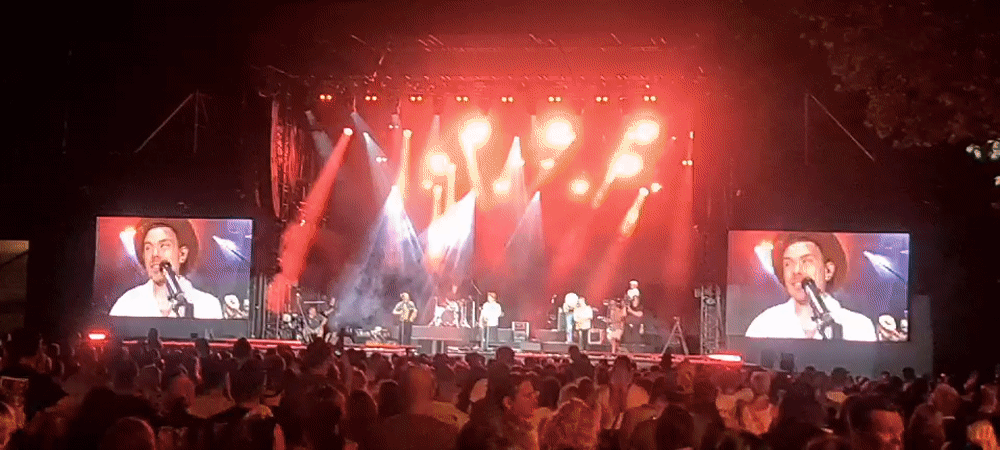 Outdoor concert night in Klagenfurt, crowd packed, stage blazing