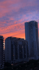 Sunset illuminates València skyline with vibrant pink orange clouds