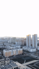 Sunset time-lapse captured over Krasnoyarsk cityscape with golden clouds
