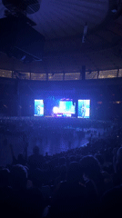 Packed arena concert in Vancouver, multiple angles, purple-lit stage