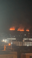 Hilltop fire with three flame areas observed at night
