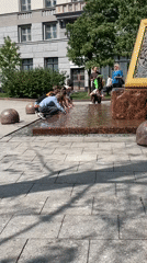 Young people interact with fountain in public plaza