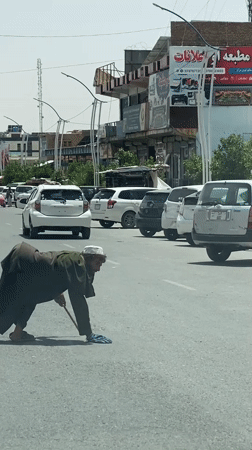 Navigating Kandahar streets with a cane in traditional dress
