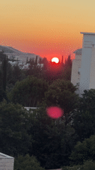 Deep red sunset over Karmiel's rooftops and trees
