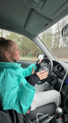 Woman in green jacket drives car in Chaikovsky, Russia