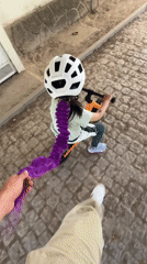 Child rides balance bikes on cobblestone paths in Vila Real