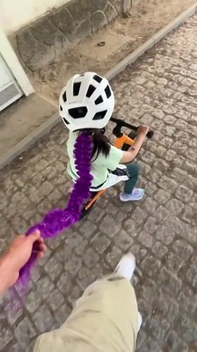 Child rides balance bikes on cobblestone paths in Vila Real