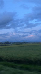 Vehicle travels through rural Mendoyo landscape at dusk