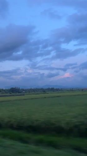 Vehicle travels through rural Mendoyo landscape at dusk