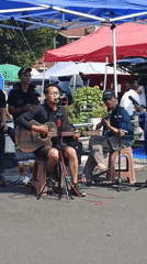 Live street music under a blue tent in Cilacap