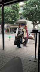 Two women walk past Tel Aviv cafe