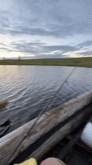 Fishing from a wooden rowboat at dusk, rural Belarus