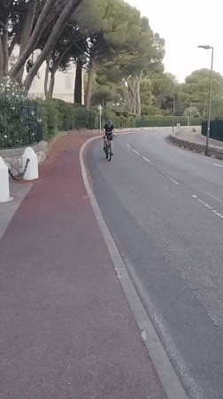 Cycling past the gates of Hôtel du Cap-Eden-Roc, Antibes