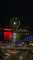 Doha waterfront Ferris wheel displays colorful lights in evening footage