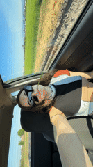 Passenger chews grass while driving through Bulgarian countryside