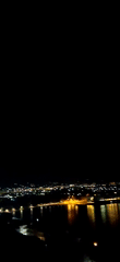 Waterfront evening in Aegio with roses, crowds, and city lights