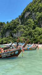 Boats anchored in turquoise waters off a Thai island