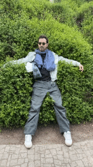 Man performs playful antics near Mother of Georgia statue