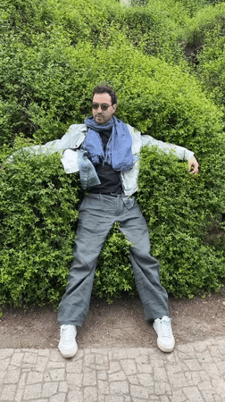 Man performs playful antics near Mother of Georgia statue