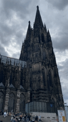Tourist captures panning video of Cologne Cathedral on cloudy afternoon