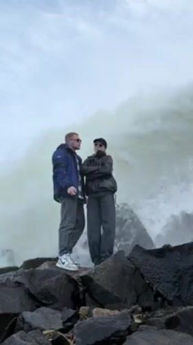 Couple poses for photos at waterfall in Chernushka, Russia