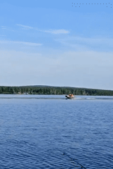 Boats and calm water on a Russian lake, summer afternoon