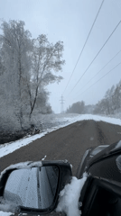 Vehicle travels snow-covered road in Razdolye, Russia