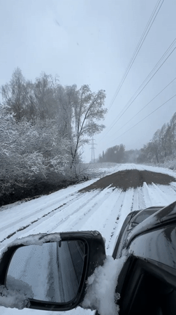 Vehicle travels snow-covered road in Razdolye, Russia
