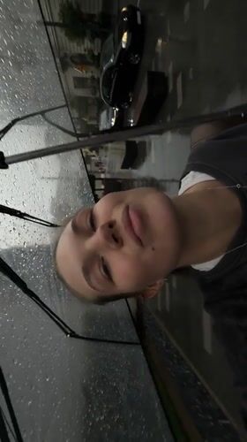 Woman films rainy selfie video with umbrella in Belgrade