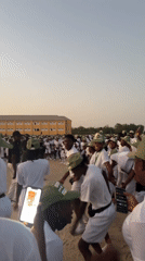 Young adults gather in formation on field in Maiduguri