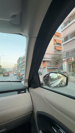 Woman blows kiss to camera while sitting in car