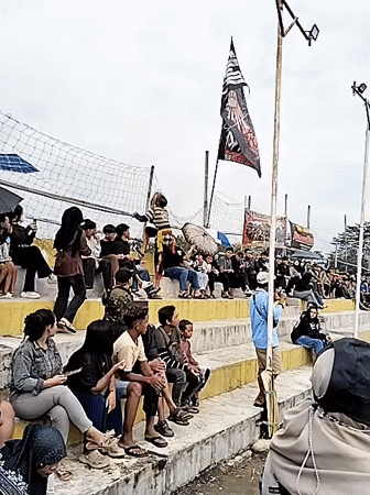 Traditional dancers perform for crowds in outdoor arena, Kuto Indonesia