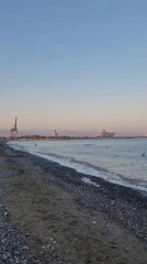 Sunset on a Cyprus pebble beach, cruise ship on the horizon