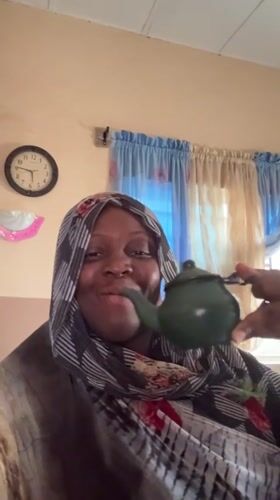 Woman enjoys tea from green teapot in Madangala home