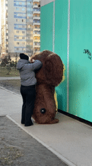 Person assists costumed figure on Kudrovo sidewalk