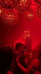 DJ performs at red-lit Moscow nightclub during evening hours