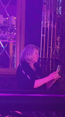 Woman uses phone in Riga booth Friday evening