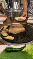 Pork belly and vegetables grilling over coals in Đà Nẵng