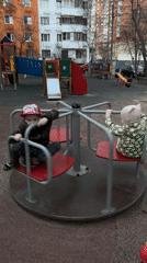 Children play on merry-go-round at Khimki playground