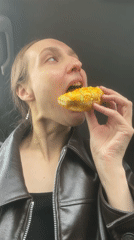 Woman enjoys decorated donut in car in Sharkan