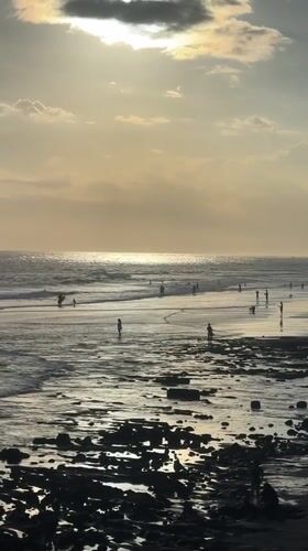 Golden hour beach gathering with surfers in North Kuta