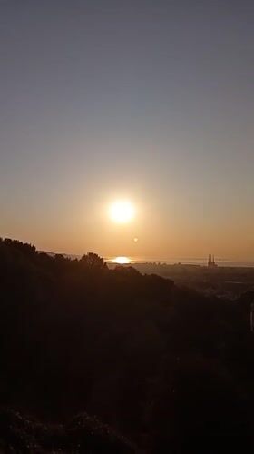 Barcelona at sunrise, golden light over the city below