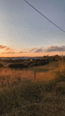 Warm sunset light over Cascais, clouds and power lines included.