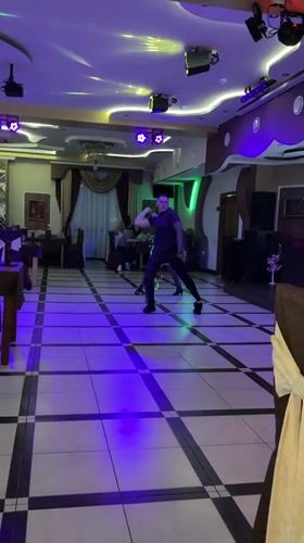 Couple performs dance routine with light whip in Miass ballroom