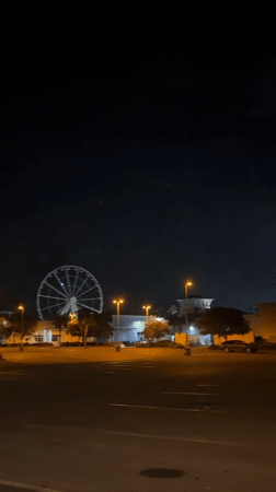 Ferris wheel lights glow over a quiet Panama City Beach night.