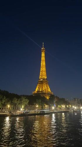 Eiffel Tower illuminated golden against evening skies in Paris