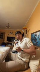 Man with vodka bottle poses with flowers in Burgas home